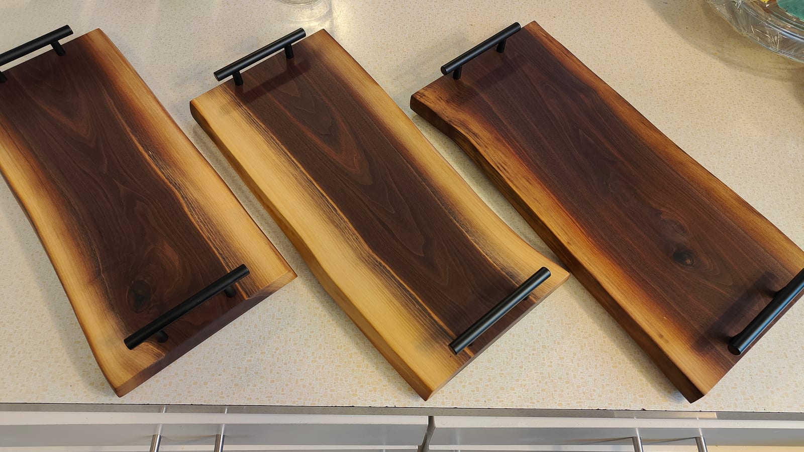 Two handcrafted live edge walnut trays with natural wood grain