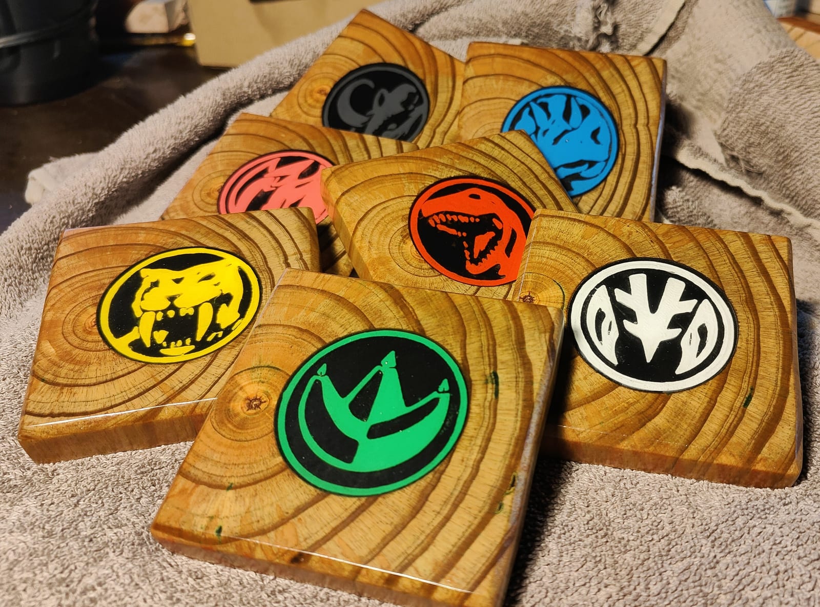 Wooden Power Rangers coasters with colorful 3D-printed power coin inlays